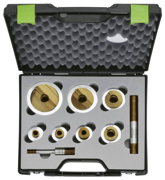 Open black and green case containing eight golden annular cutters and a long adapter, all set in grey foam with custom cutouts.