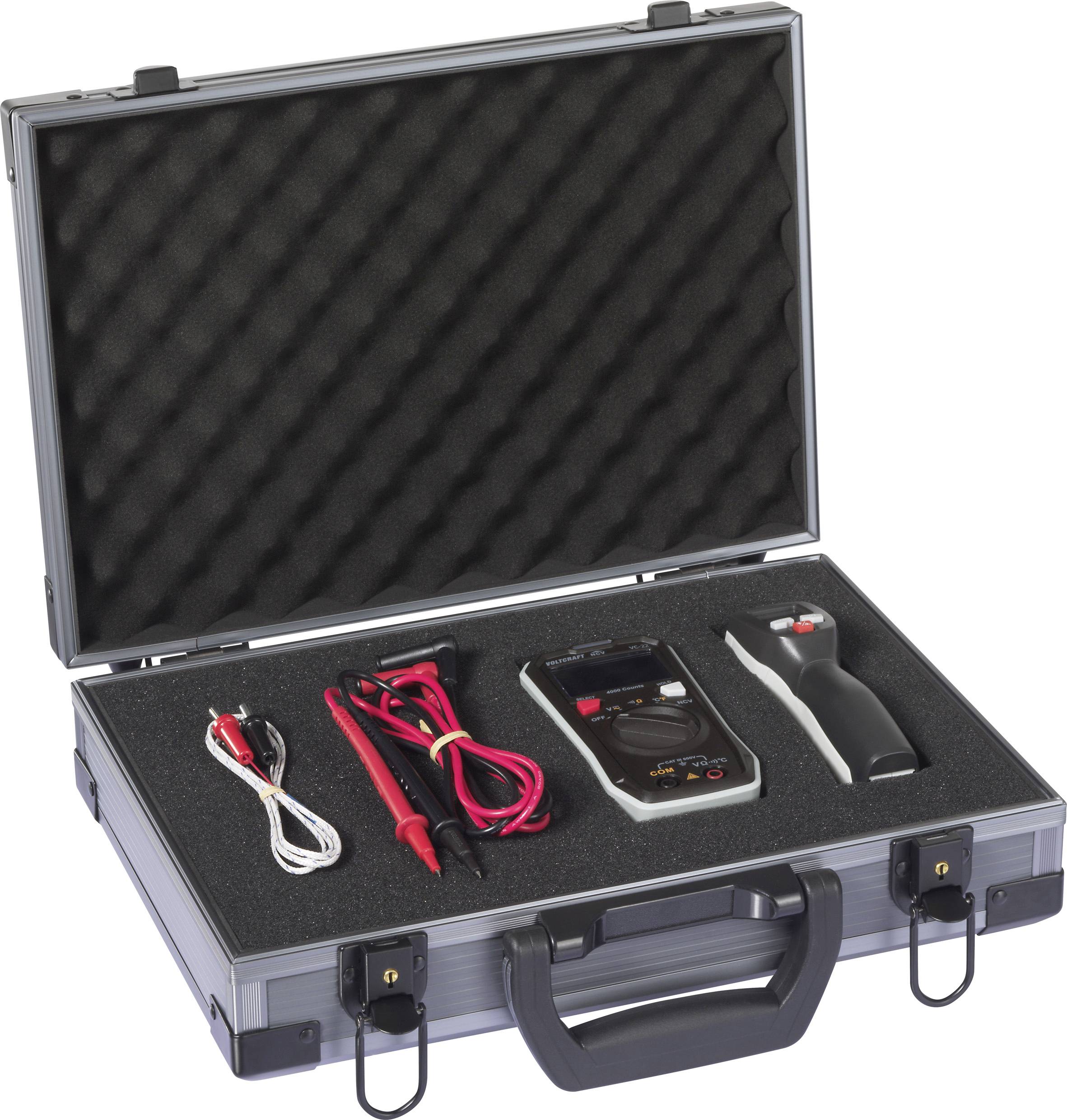 An open tool case with electronic testing equipment, including a multimeter, probes, and a black device, all placed in foam cutouts.