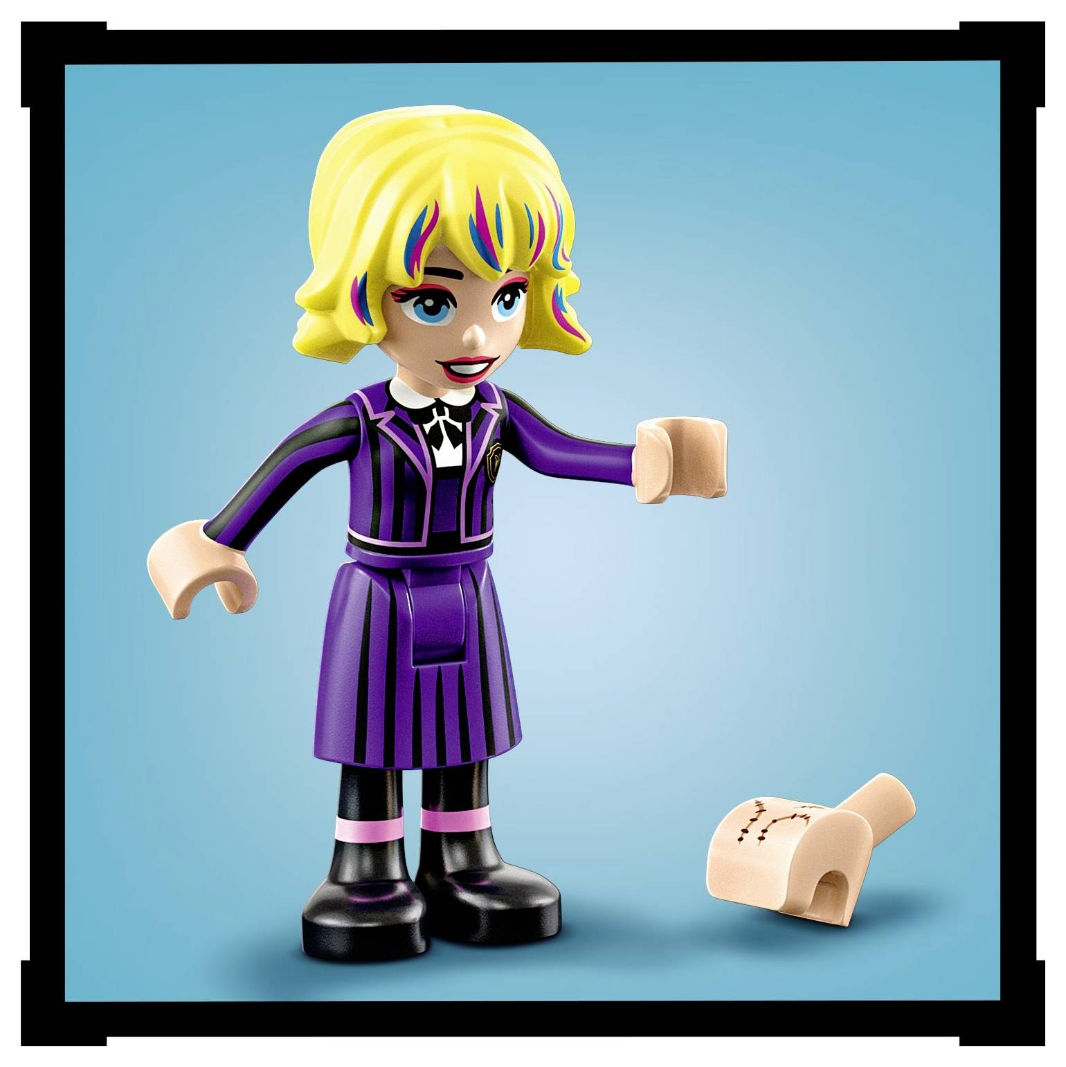 A colorful toy figure with yellow hair in a purple outfit stands on a blue background, next to a small scroll on the ground.
