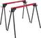 Two red and black metal sawhorses with folding legs, designed to support wood or other materials during construction or woodworking tasks.