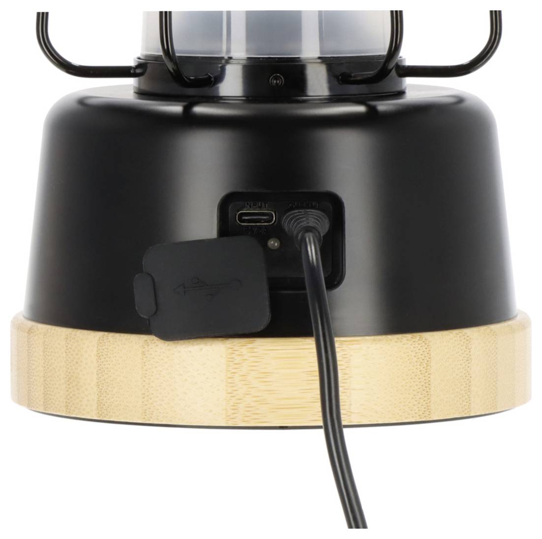 Close-up of a black and bamboo lantern base with a charging port and power cable plugged in.
