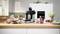 A kitchen counter with a coffee grinder surrounded by breakfast items like berries, granola, and juice, suggesting a morning routine.