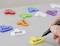 A hand writes on a yellow key tag labeled 'Audio'; various other labeled tags like 'Phone', 'DVD', 'Lamp' are scattered on a surface.