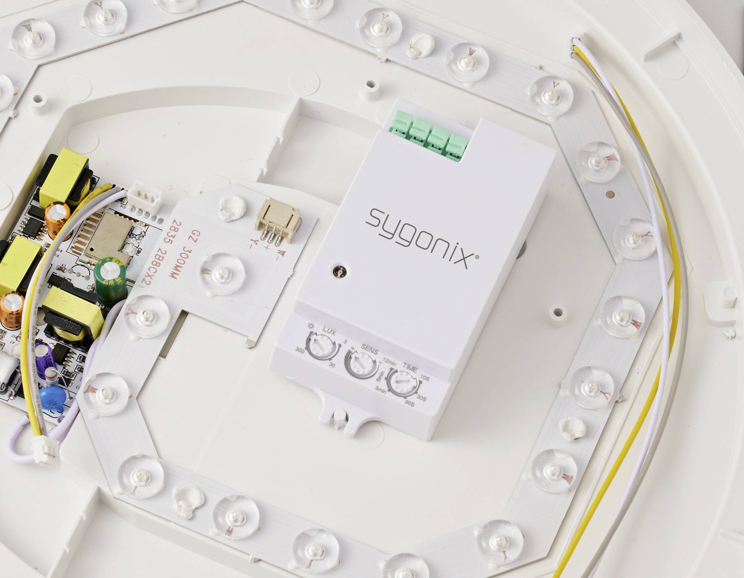 'LED ceiling light with open cover, showing Sygonix controller, circuit board, LEDs, and wiring.'