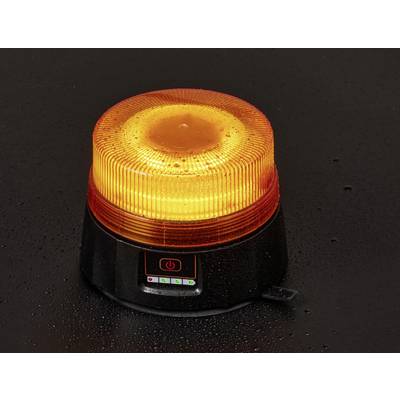 An orange warning beacon with a power button, on a dark, wet surface, indicating it's turned on, likely for safety or alert purposes.