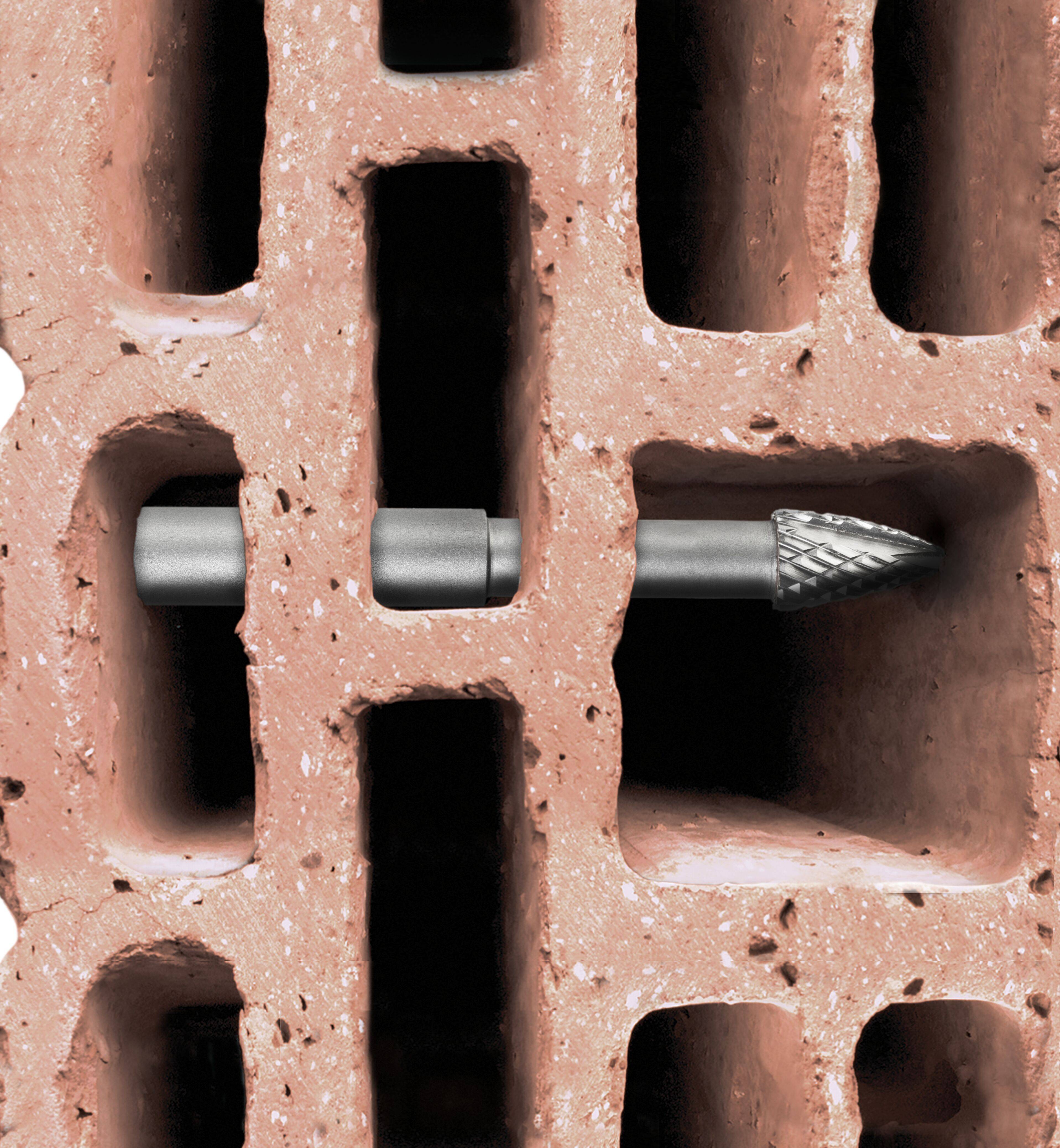 A drill bit penetrating a red perforated brick at an angle, showing its ability to create precise holes in construction materials.