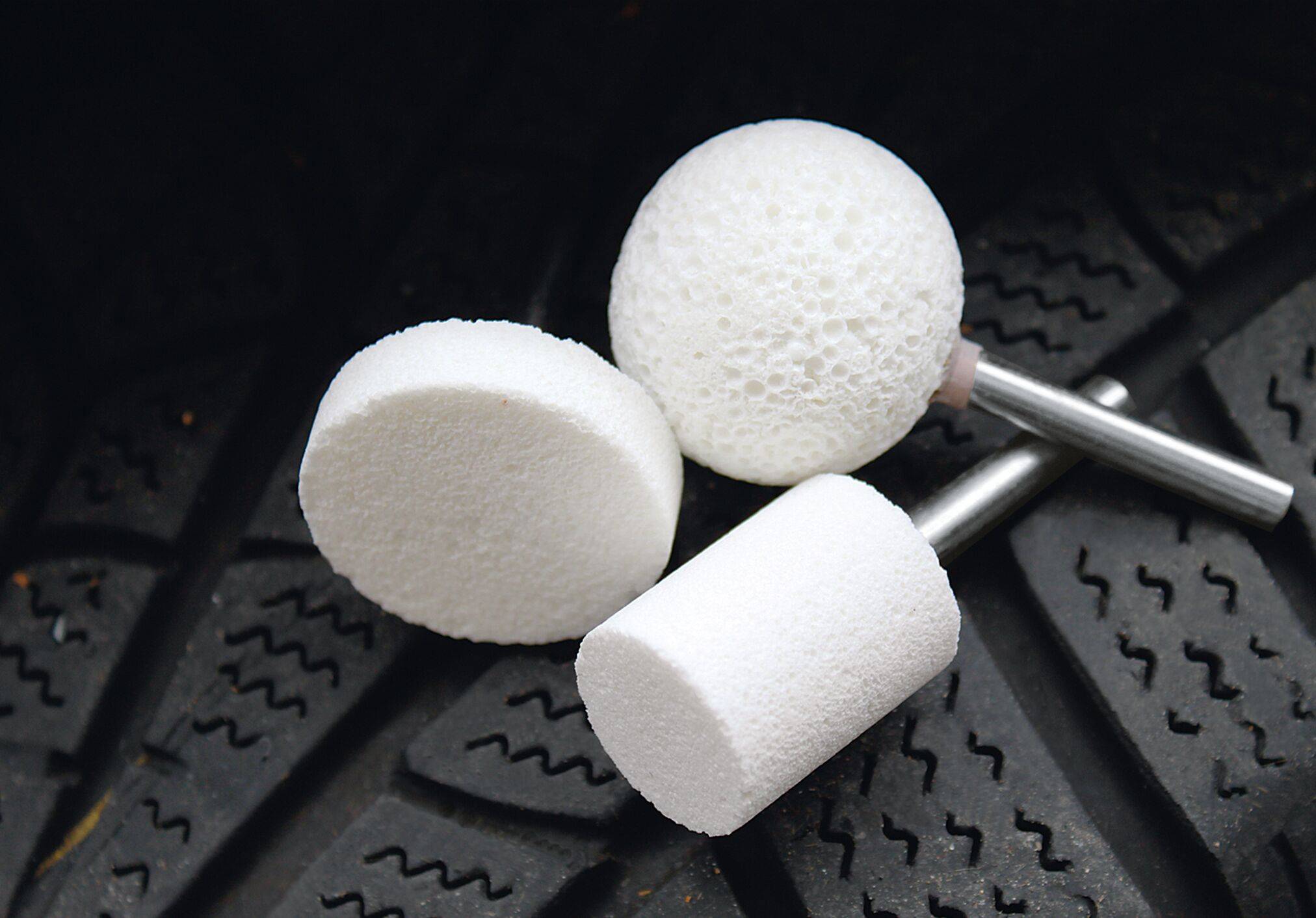 White polishing attachments on textured rubber surface, likely used for cleaning or smoothing.