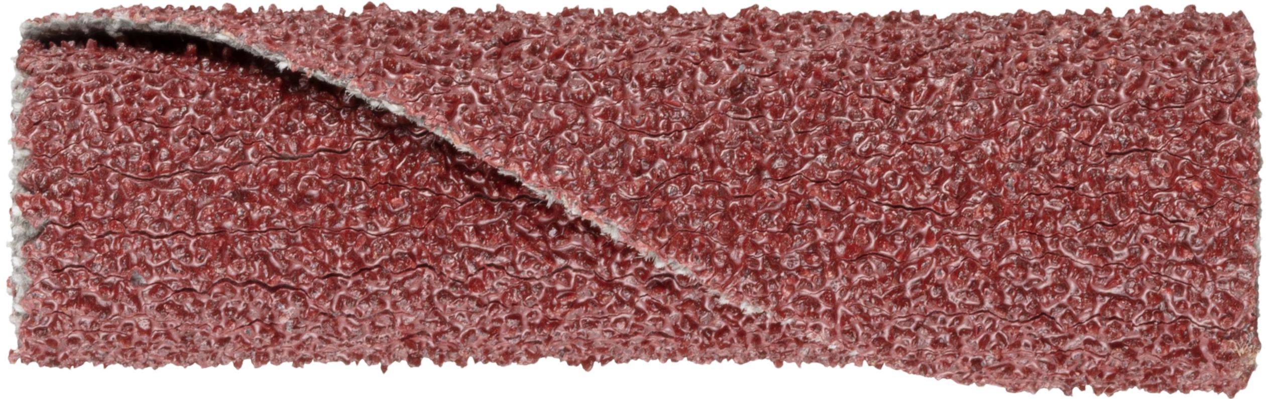 A close-up of a textured red abrasive strip, showing its rough surface and layered structure, used for sanding or smoothing surfaces.
