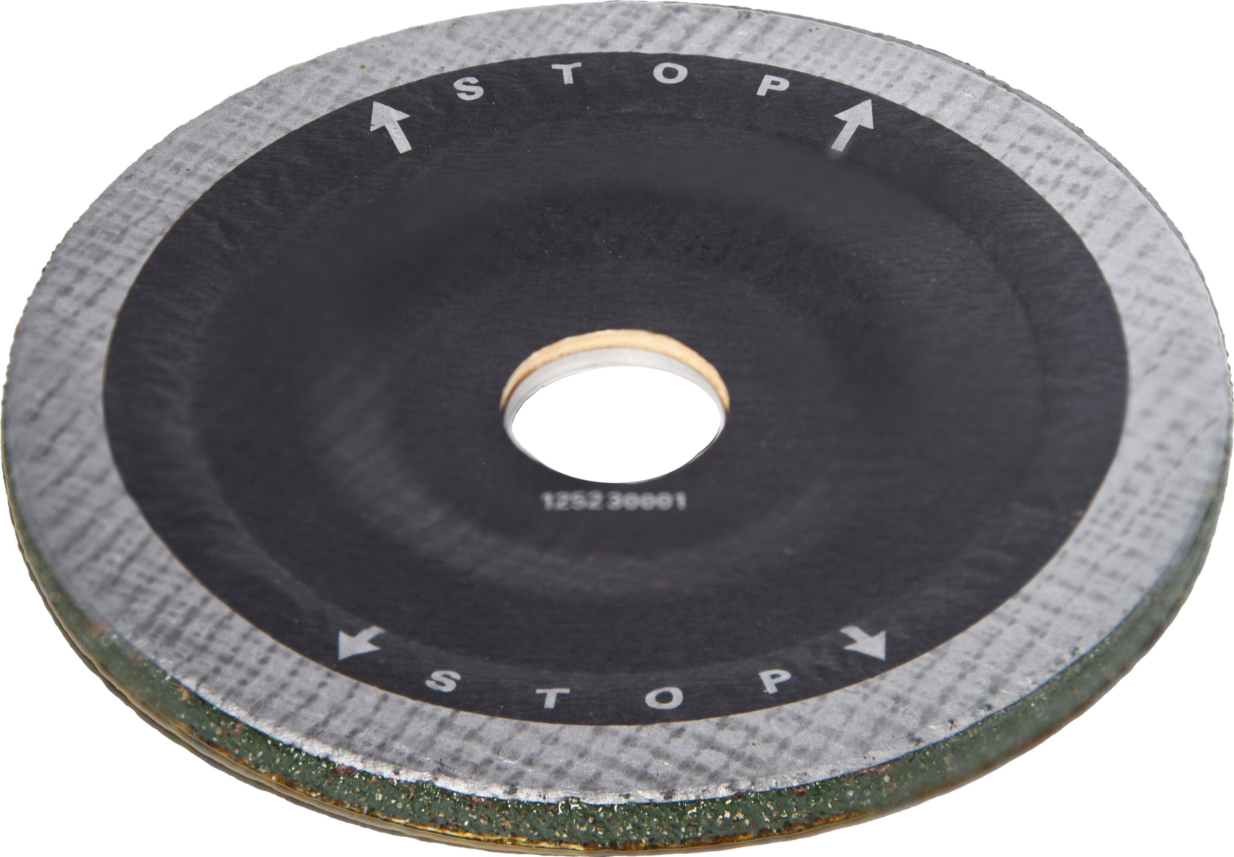 A circular grinding disc with arrows indicating a stop direction is shown. The outer edge is textured, and the center has a hole.
