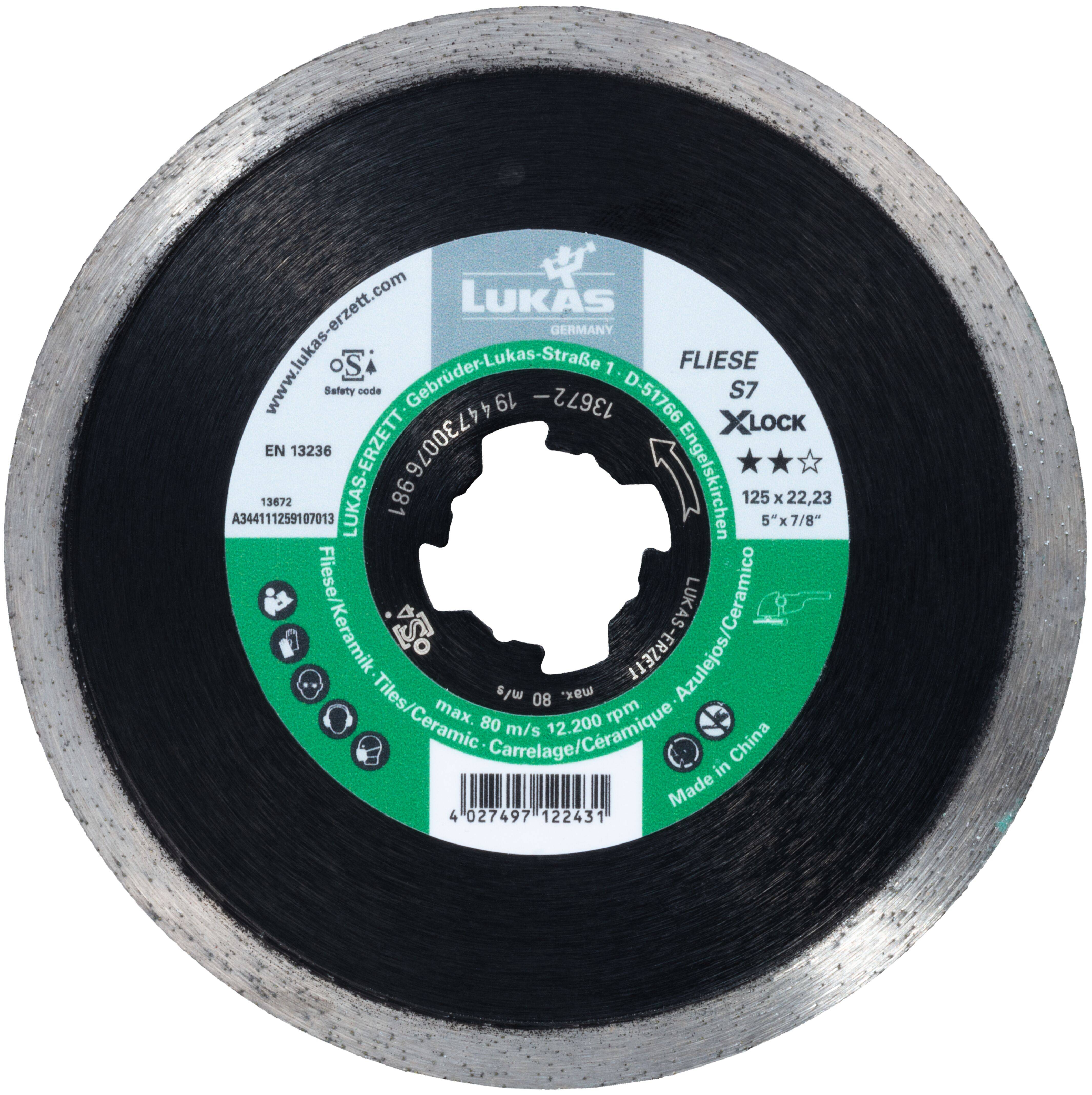 Close-up of a Lukas Germany diamond cutting disc with green label, showing model 'Fliese S7 Xlock', size 125 x 22.23 mm, and safety icons.