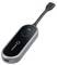 'A black remote with a circular button labeled TX on its surface, connected by a short, flexible cable to a USB-C connector.'