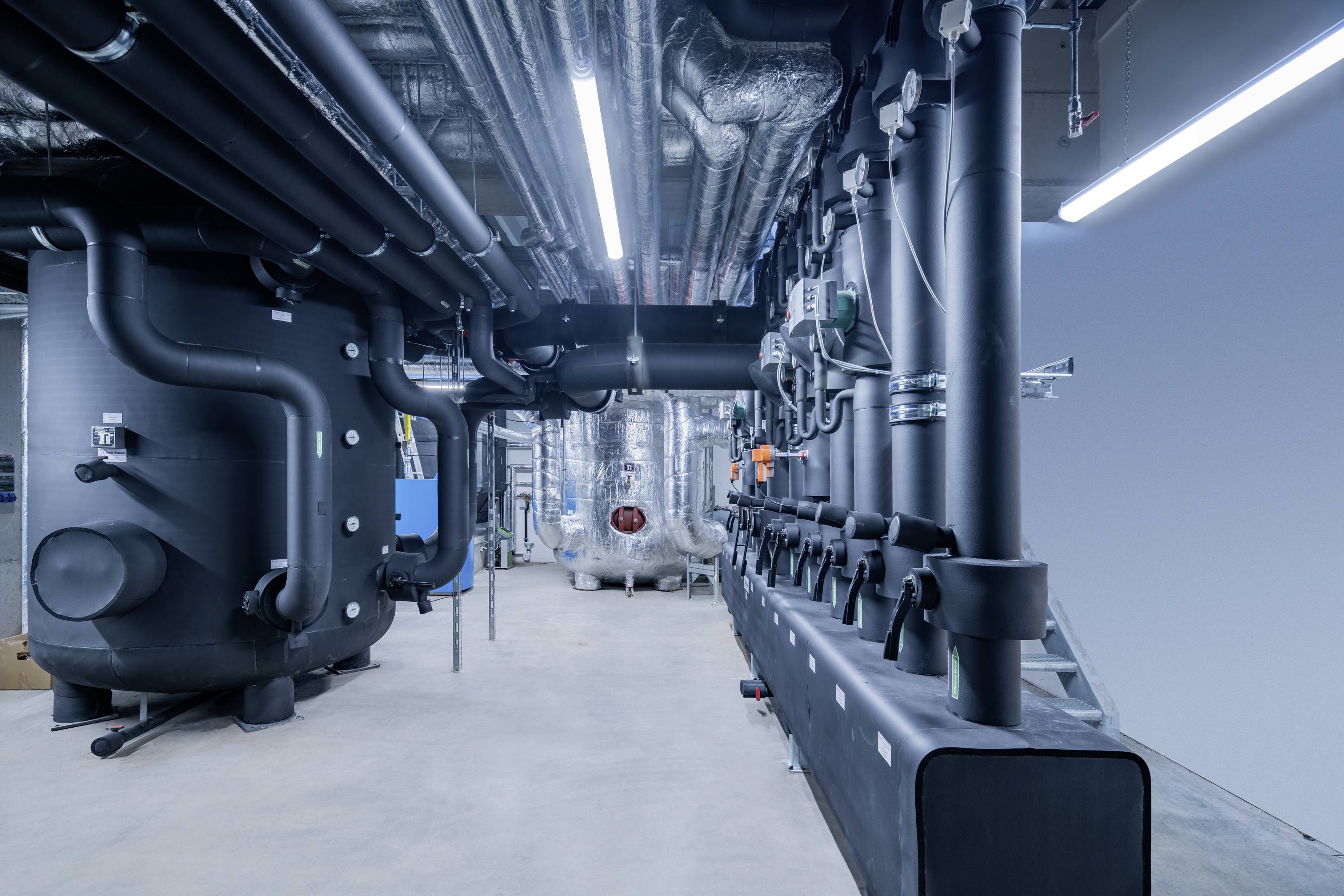 A spacious factory floor with advanced machinery, metal platforms, and a worker operating equipment, illustrating industrial automation.