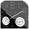 A clock with white numbers and hands on a black face shows about 2:10. Below, dials display humidity and temperature readings.