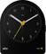 A black analog Braun alarm clock with white hour and minute hands, yellow second hand, and round dial with white numbers on a black face.