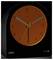 A black Braun quartz alarm clock with an orange face and black numerals shows the time as 10:10. A green light indicates the alarm is on.