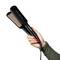 A hand holding a Remington hair straightener with a black body and copper-colored heating plates, set against a plain white background.