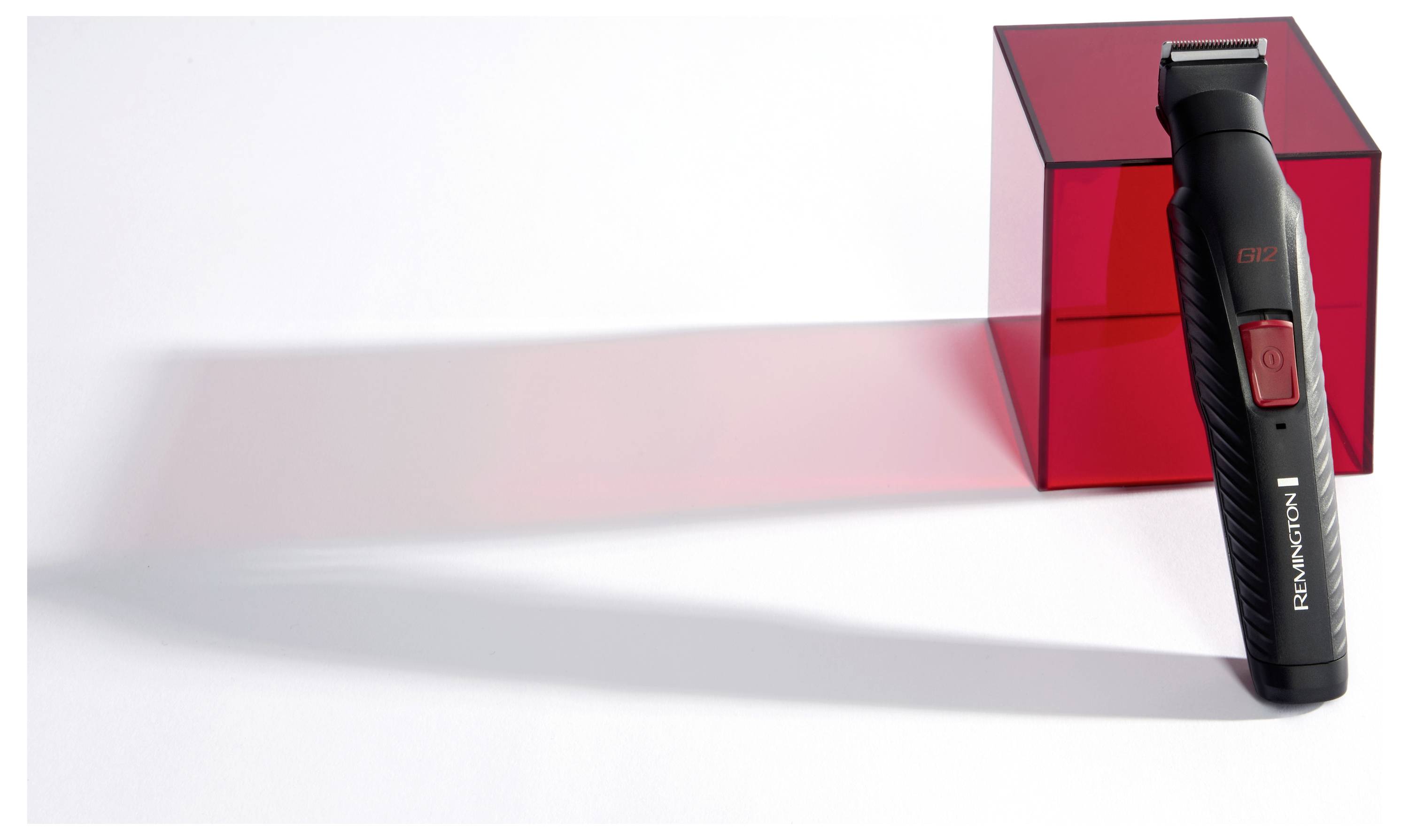 A black and red Remington electric trimmer is standing upright next to a translucent red cube, casting a matching shadow on the surface.