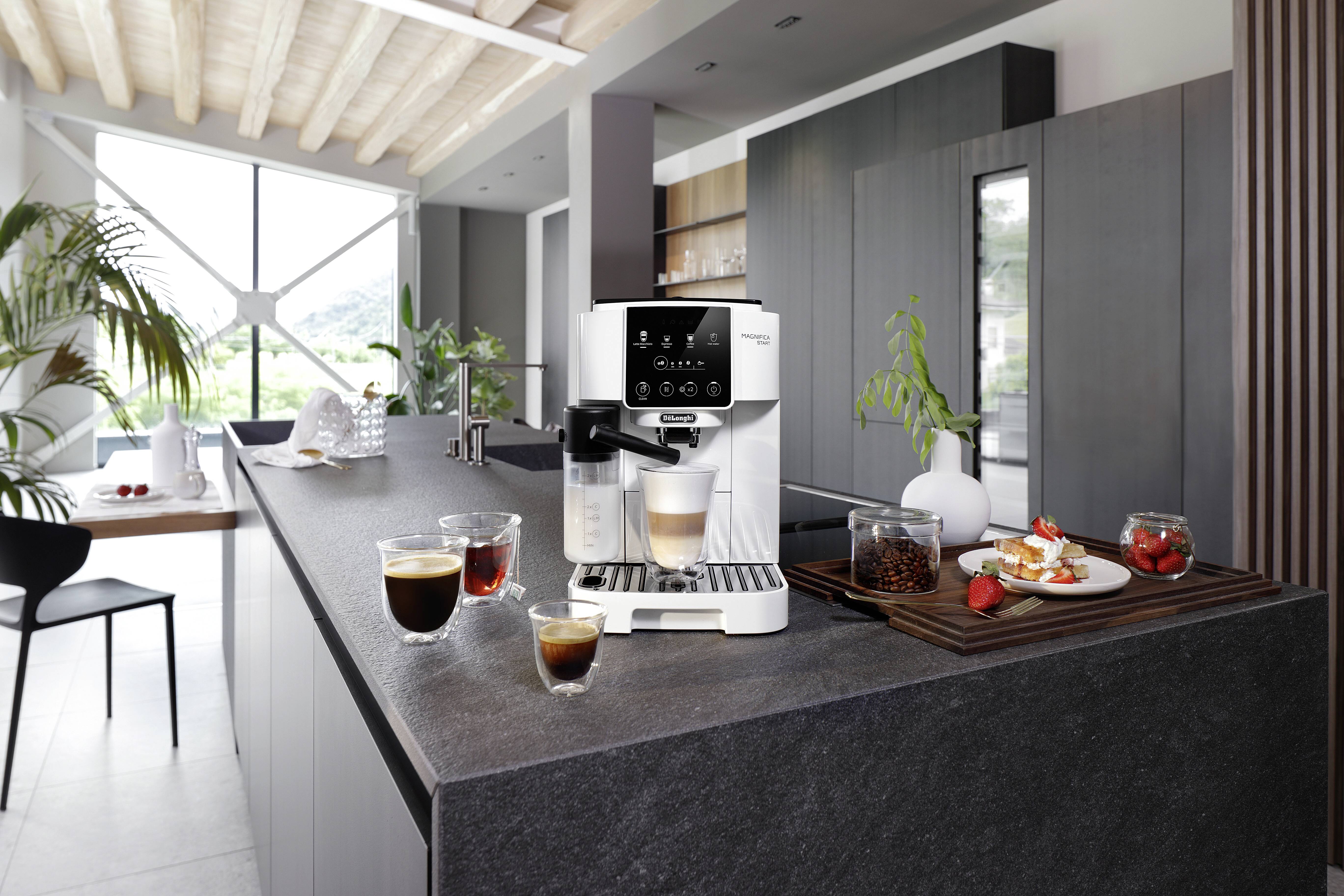 A modern kitchen featuring a sleek espresso machine on a dark stone countertop, surrounded by various freshly made coffee drinks.