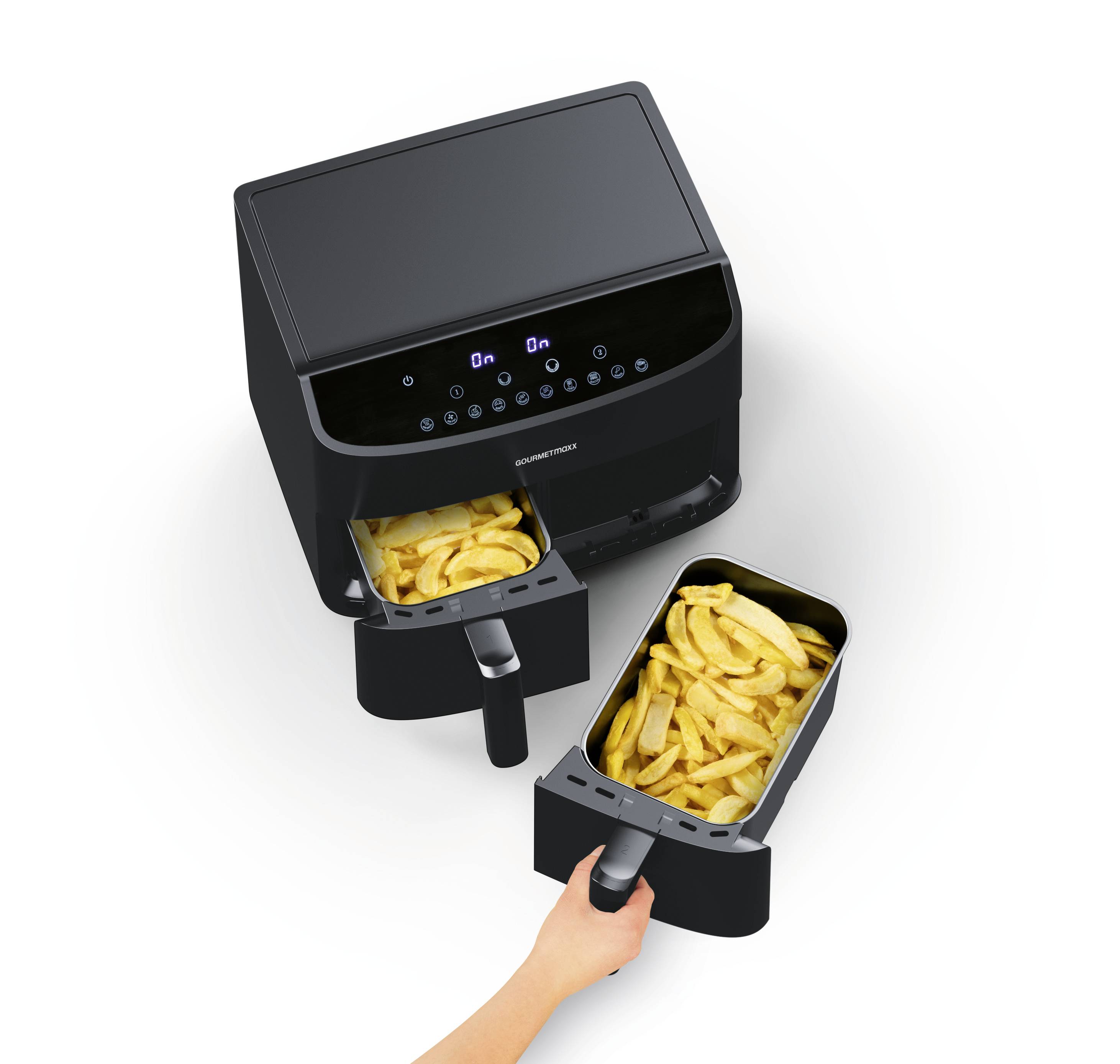 A double compartment air fryer with digital controls is open, revealing golden french fries in each basket. A hand holds one basket, showing a serving gesture.
