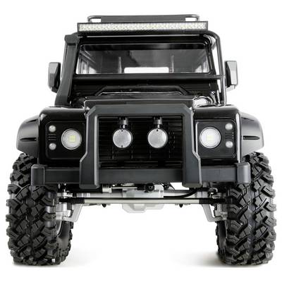A black off-road vehicle with large tires and a front grille featuring three round lights, viewed from the front.