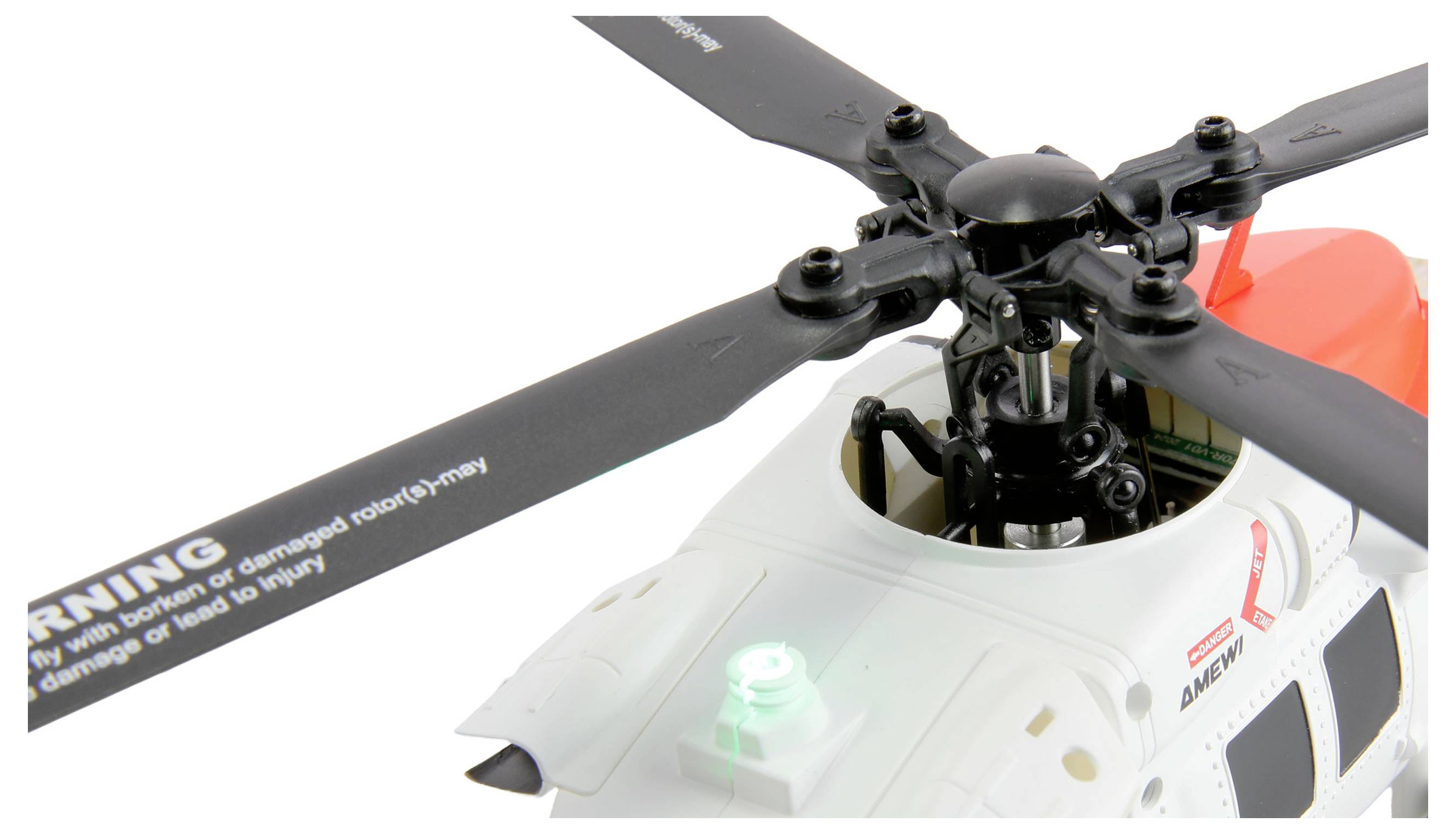 A close-up of a radio-controlled toy helicopter rotor assembly, featuring four large black rotor blades and a white body with visible warning text.