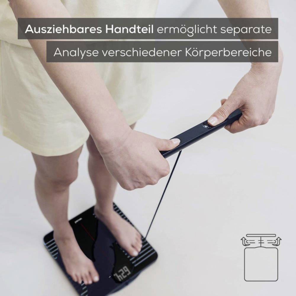 A person standing on a digital scale holding a detachable handpiece, highlighting the separate analysis feature for different body areas.