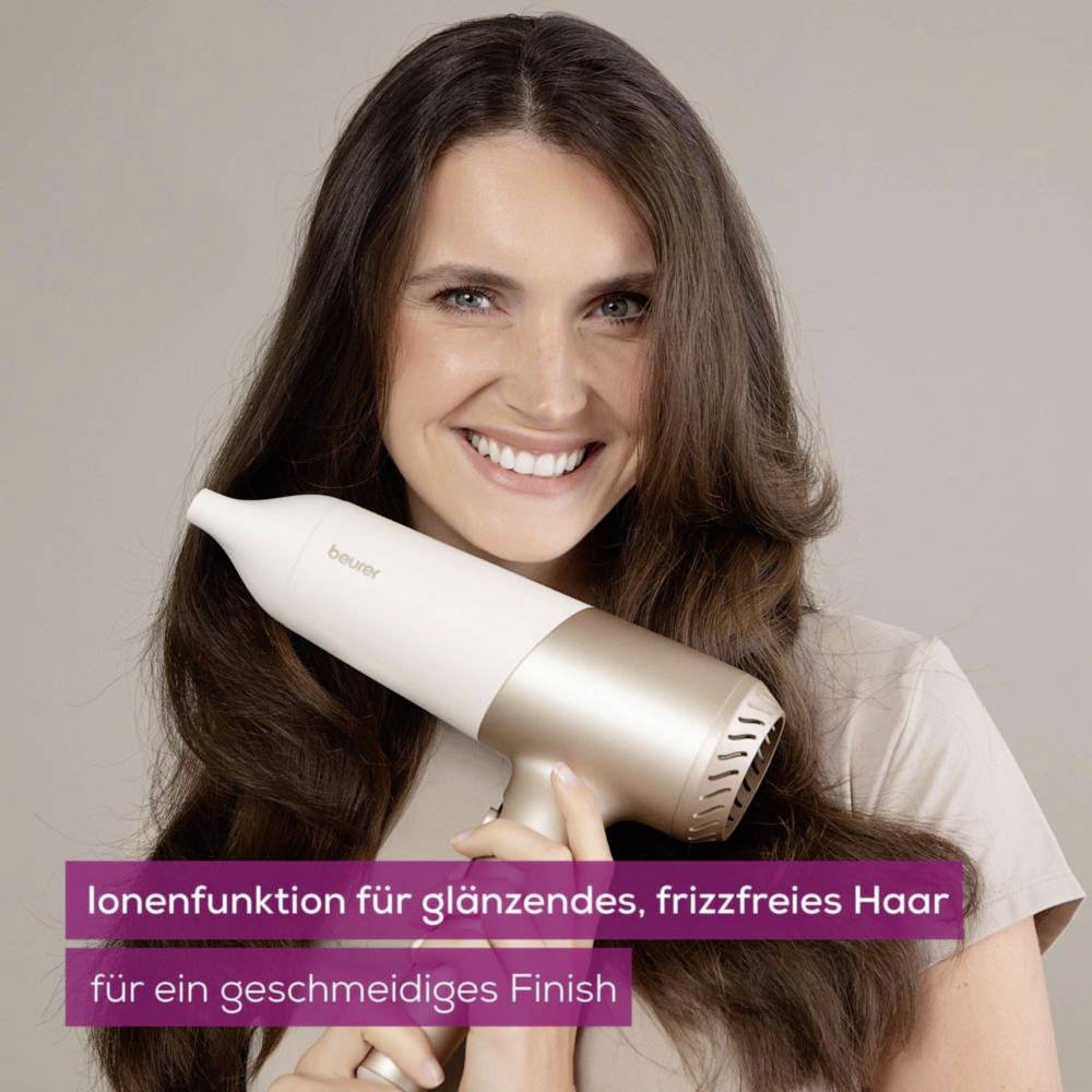A person smiles while holding a hairdryer with the text 'Ionenfunktion für glänzendes, frizzfreies Haar, für ein geschmeidiges Finish'.