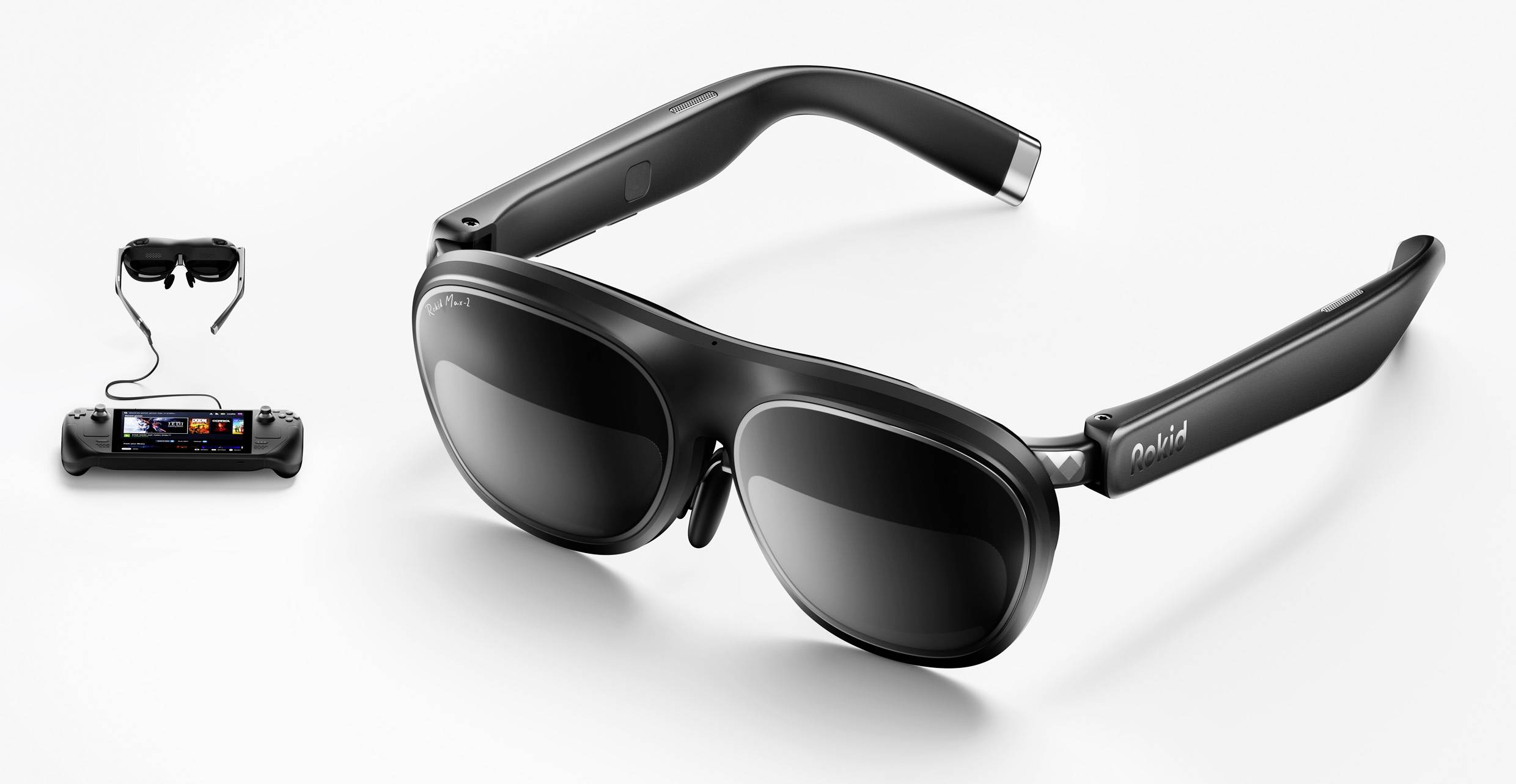 Black smart glasses with adjustable lenses, paired with a handheld gaming device connected by a cable, showcasing wearable technology integration.
