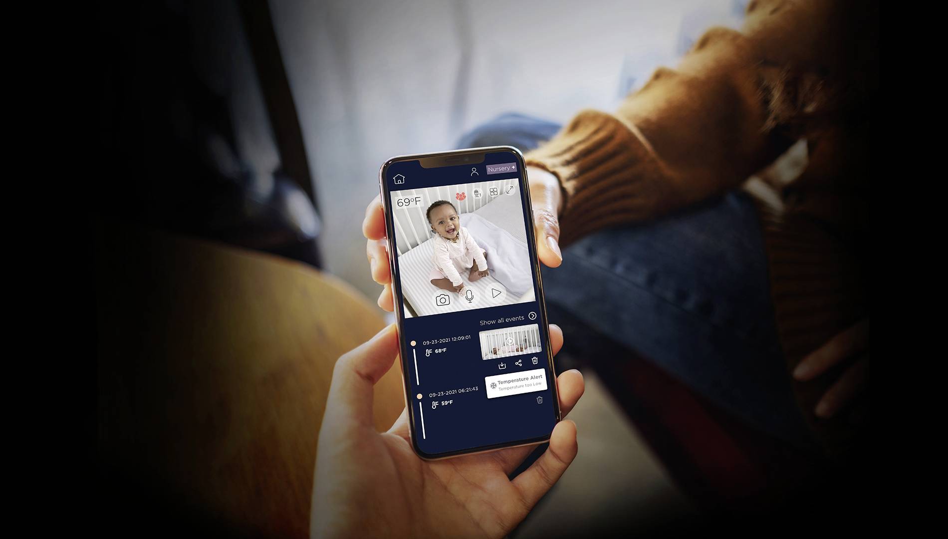 A person holding a smartphone displaying a video editing app, showing a video clip of a baby and editing tools.