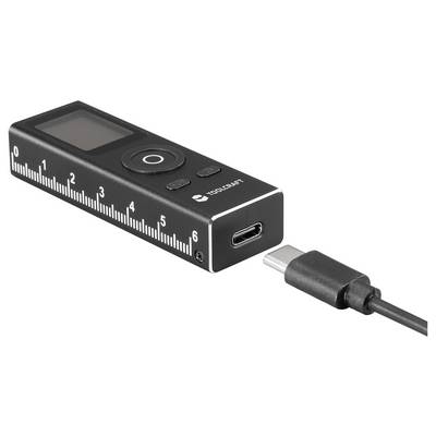 A compact black digital device with a USB-C port and an LCD screen, featuring a ruler-like design marked from 0 to 6 centimeters.