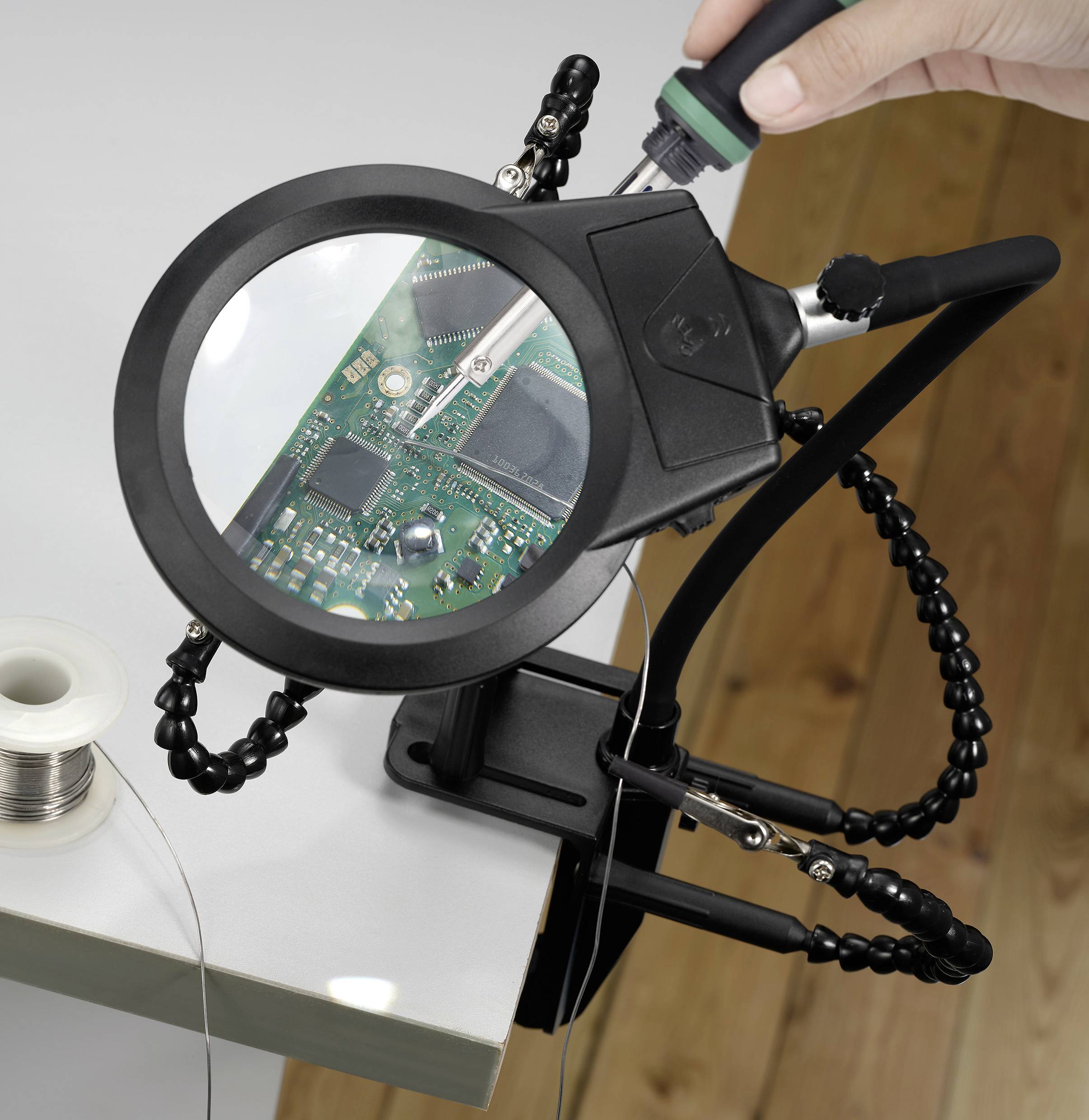 A person uses a magnifying tool to solder components on a green circuit board, indicating electronics repair or assembly work.