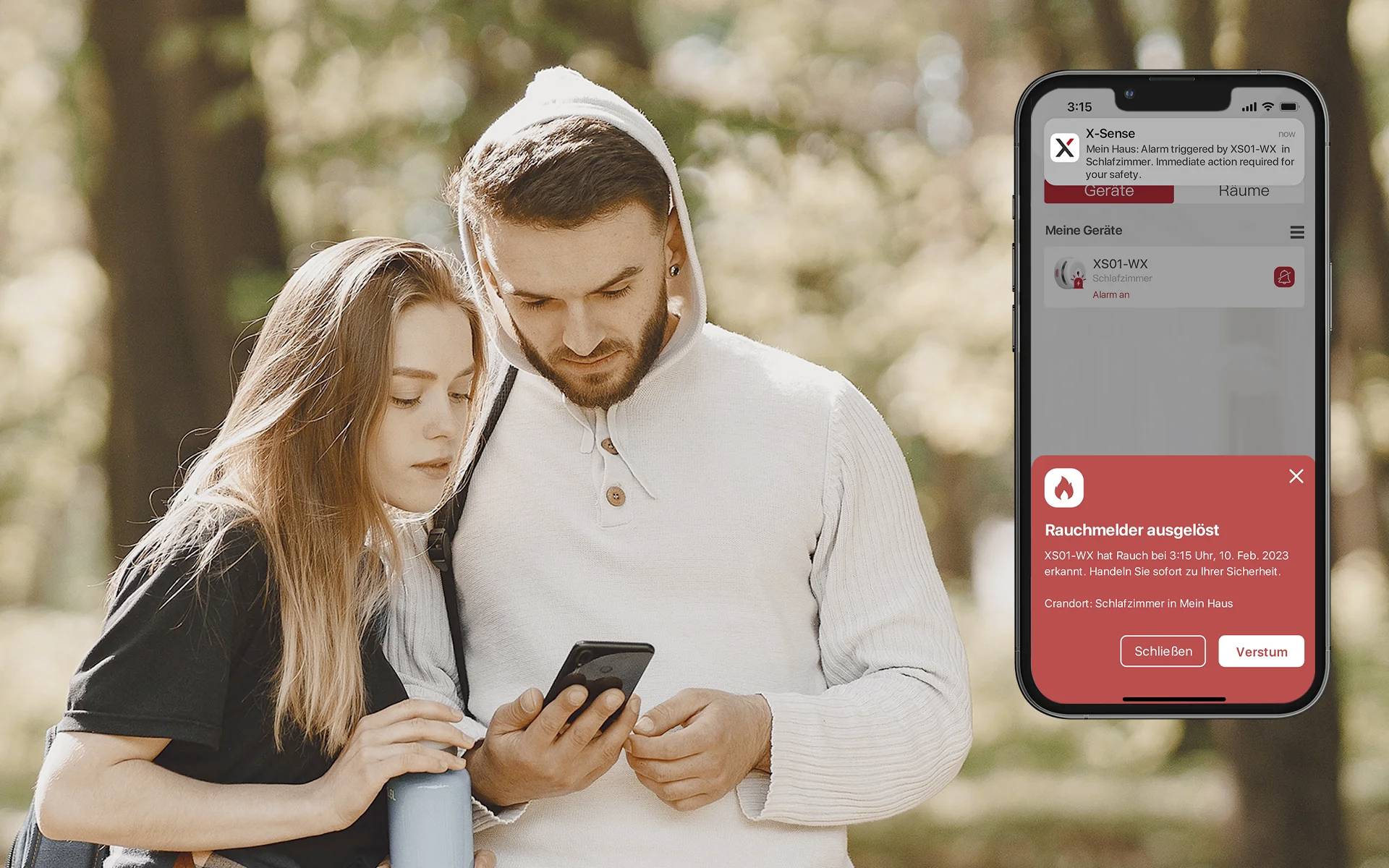 A man and a woman are examining a smartphone outdoors. On the right, a smartphone app is visible with a warning message 'Smoke detector activated!'.