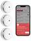 Stack of three smoke detectors next to a smartphone showing a notification: 'Smoke Alarm Triggered' with details and options to close or silence.