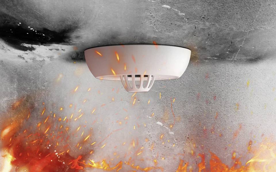 A smoke detector mounted on a ceiling amidst flames, illustrating its function in detecting fire and ensuring safety.