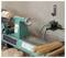 'A lathe machine and power outlet with tools on wall suggest a woodworking setup.'