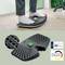 'Feet on a black ergonomic footrest with textured surface and handle and the label "Engineered in Germany" next to quality certification.'