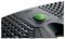 A textured black device with a prominent green button at the center, labeled 'Leitz', likely indicating a power or activation function.