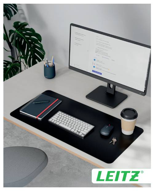 A well-organized desk with a computer monitor displaying a website, a keyboard, a notebook, a pencil, a mouse, a coffee cup, and a small plant.