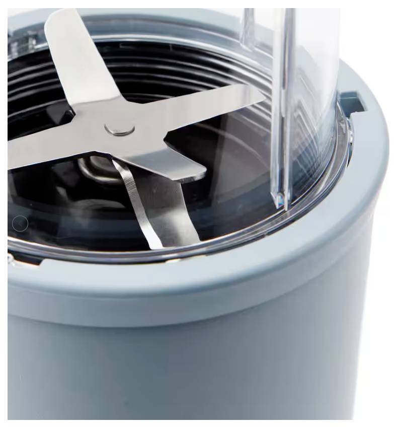 Electric blender top view showing sharp, stainless steel blades housed in a transparent, round container.