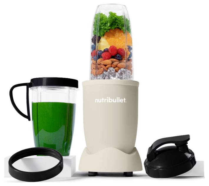 A compact NutriBullet blender filled with fruits, vegetables, almonds, and ice. Accompanied by a green smoothie in a cup, lid, and rim attachments.