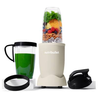 A compact NutriBullet blender filled with fruits, vegetables, almonds, and ice. Accompanied by a green smoothie in a cup, lid, and rim attachments.