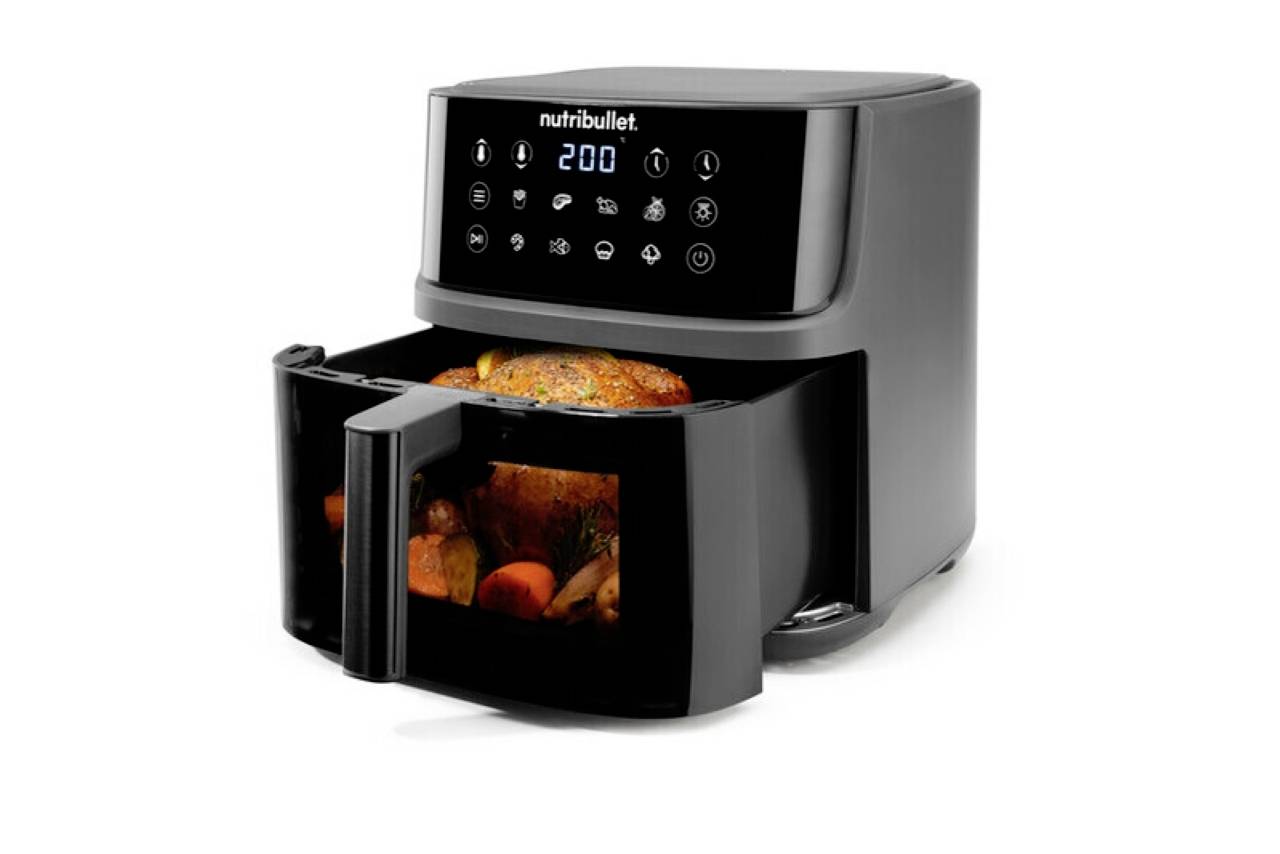 A black air fryer with a digital display shows '200' and cooking icons. Inside, a cooked chicken and vegetables are visible.