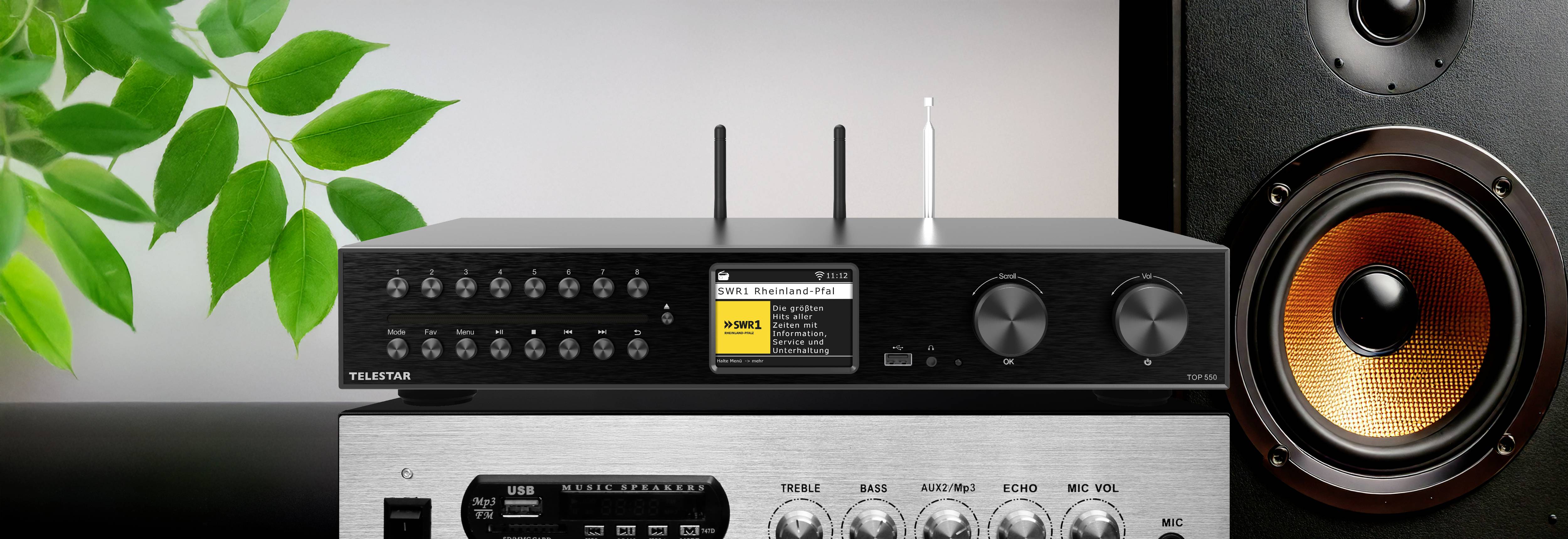 A black audio receiver with two antennas and various controls is displayed on top of a silver amplifier, next to a large speaker.