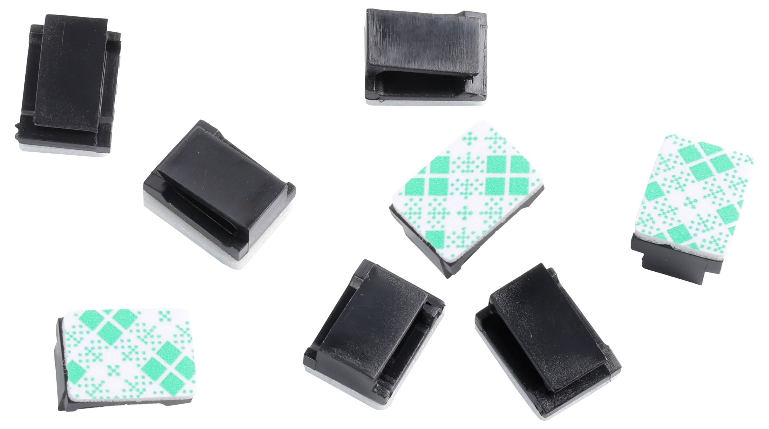 'Scattered plastic cable clips, some black, some with green geometric patterns on white, used to organize cables and wires.'