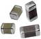 Four small, rectangular electronic components with metallic ends, possibly capacitors or inductors, vary in color between light and dark shades.