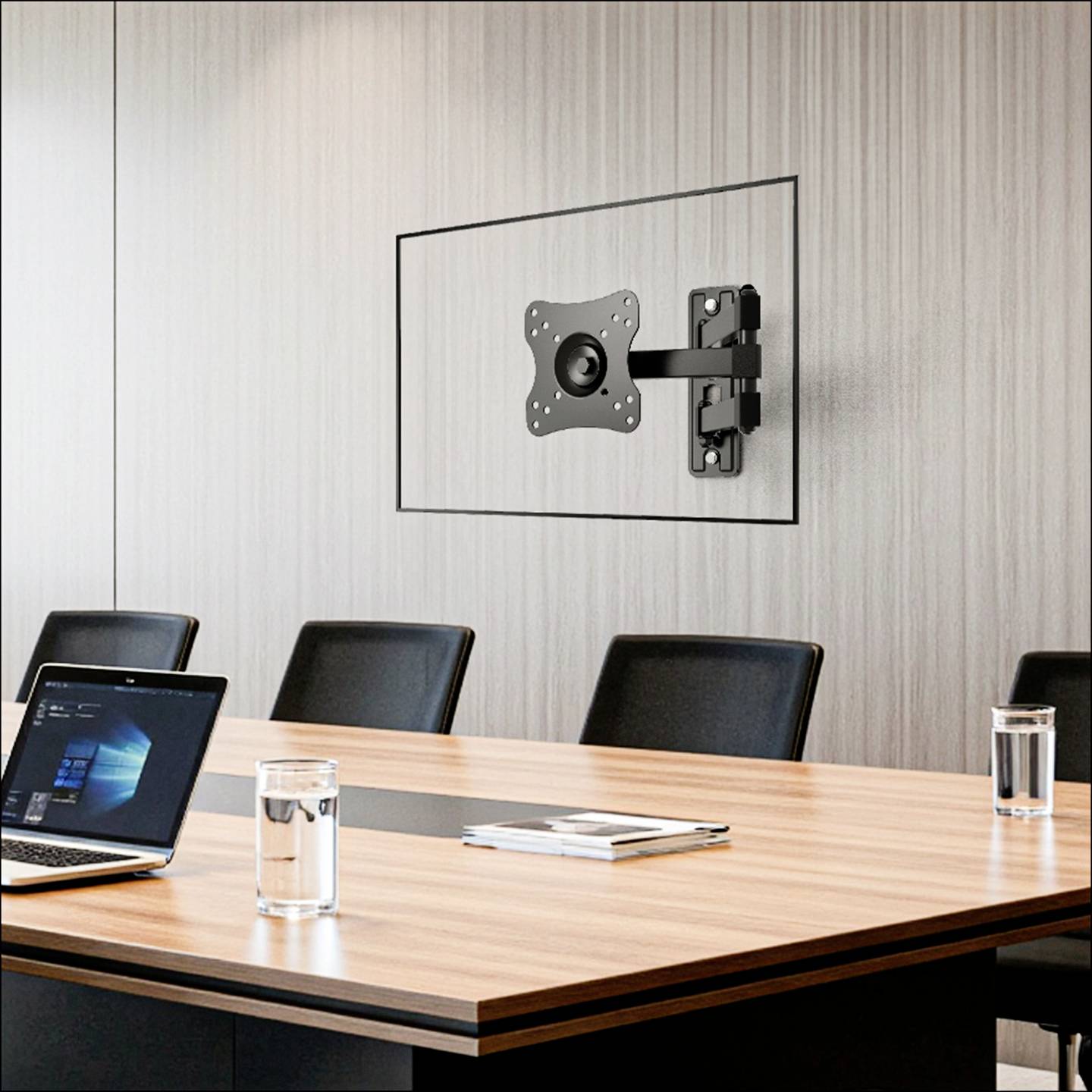 A modern conference room with a laptop on a wooden table, chairs around it, and a bracket mount on the wall for a display screen.