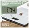 A digital kitchen scale displays '1.74 g'. Text in German promotes its precision for spices and coffee, with a capacity up to 5000 g.
