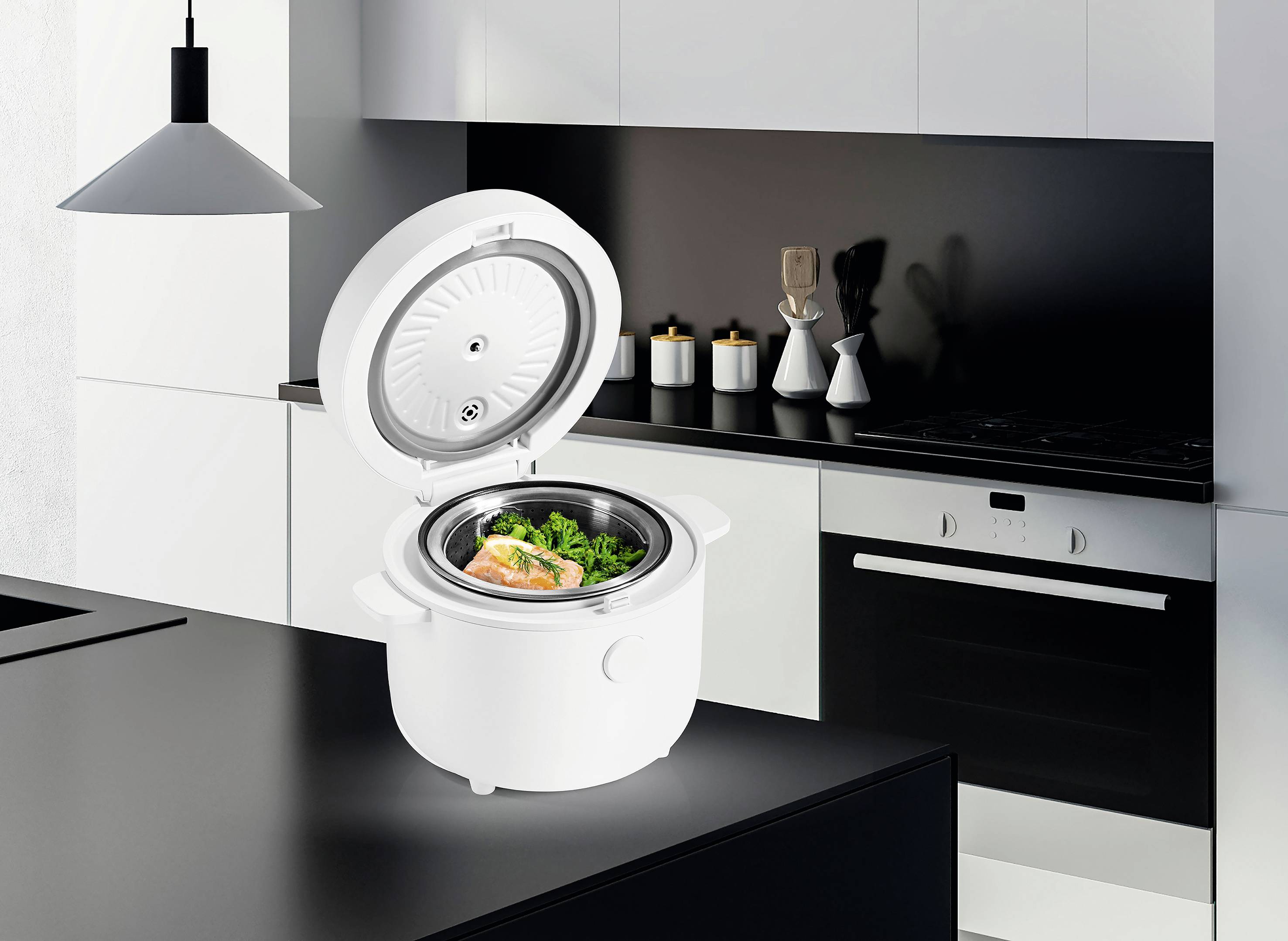 A modern kitchen with white cabinets and black accents featuring a small, open rice cooker on the counter containing salmon and broccoli.