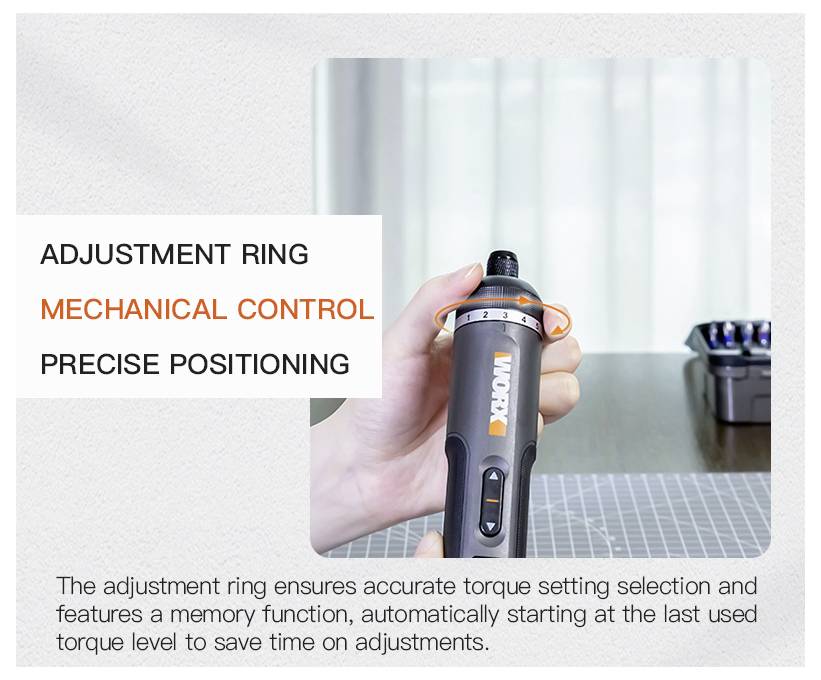 'Adjustment ring, mechanical control, precise positioning.' A hand holds an electric tool with orange accents, focusing on the adjustment ring. A box of attachments is in the background on a table.