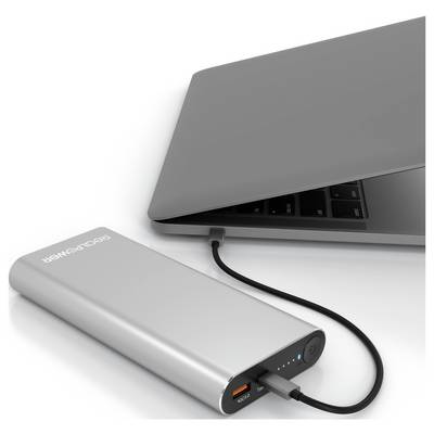 A silver power bank connected to a closed laptop with a black cable, showing charging status lights on the power bank.